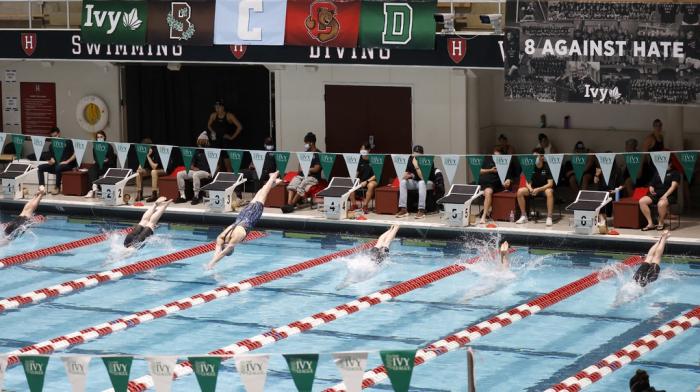 Swimmers including Penn's Lia Thomas, lane 4, dive into the water at the start of a qualifying heat of the 200 yard freestyle at the Ivy League Women's Swimming and Diving Championships at Harvard University, Feb. 18, 2022, in Cambridge, Mass.