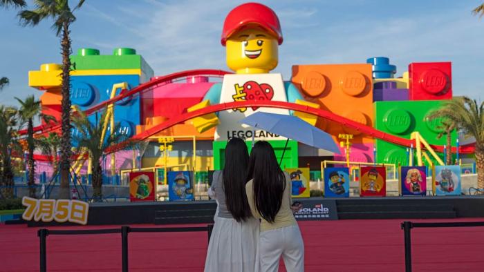 Women look at a giant Lego character at Legoland Shanghai a day before it opens to the public in Shanghai, China, Friday, July 4, 2025